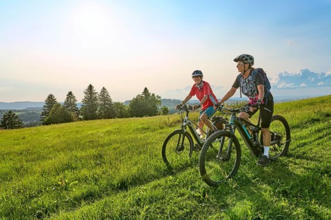 Two senior girlfriends have fun during a e-bike cycling tour in the Allgau Alps near Oberstaufen,