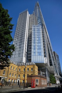View of The Shard skyscraper, a historic brick building and a red telephone box, London Bridge,