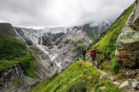 Mountaineers on a hiking trail, dramatic mountain landscape with Grindelwald-Fiescherfirn glacier,