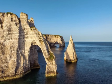 Aerial view of the Porte d'Aval rock formation with the free-standing Aiguille d'Étretat rock pin