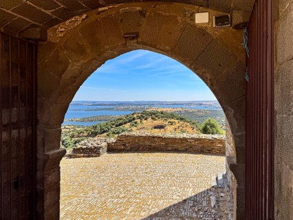Stone arch with view of surrounding countryside and water seen from a castle, Monsaraz, Évora,