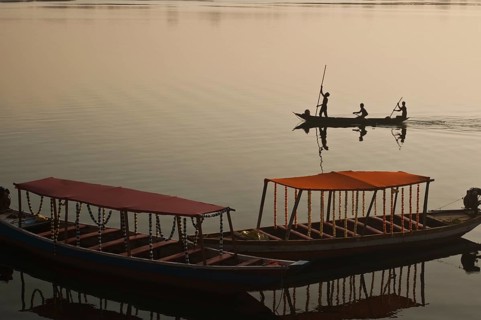 Fishermen are boating on the Mahanadi river (Chhattisgarh, India) . Foreground : tourboats