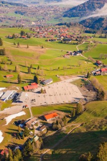 A village with numerous buildings and open fields in a hilly landscape, Allgäu, Bavaria, Germany