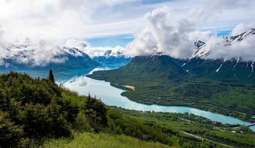 View of snowy mountains in spring and turquoise Kenai Lake with reflection, Slaughter Ridge Trail,
