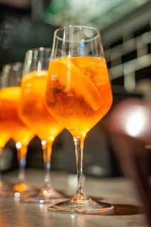 Three glasses with spritz and orange pieces are standing in a row, Cafe Kuh, Deckenpfronn, Germany