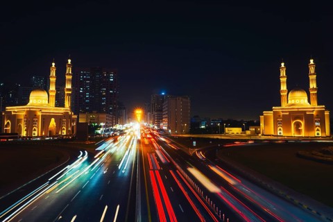 Night long exposure Sharjah Four Khalifas intersection.UAE futuristic architecture. Illuminated