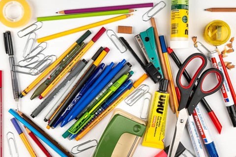 A jumble of stationery and office supplies on a white surface