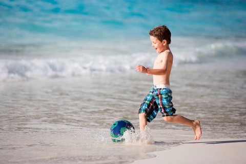 A young boy playing soccer on the beach, Seychelles, La Digue, La Digue, Indian Ocean, Seychelles