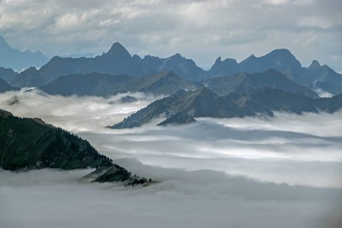 View from the Nebelhorn summit to mountains of the Allgäu Alps, mountains rising from fog in the