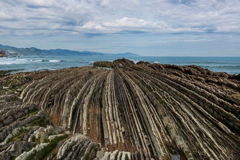 Distinctive rock cliffs as a geological formation of rock layers, Flysch on Itzurun Beach in