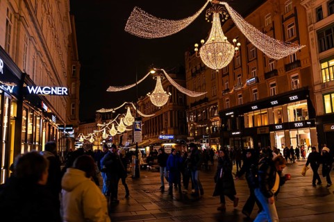 Vienna, Austria - 15 December, 2025: Busy street in Vienna, Austria, illuminated by festive lights.