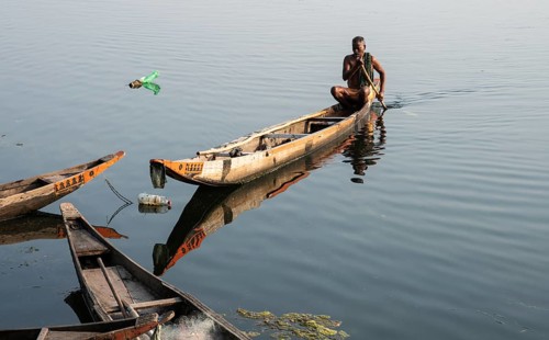 Local fisherman, Mahanadi river, Sonepur, Odisha, India. Bottles on the surface of the water are