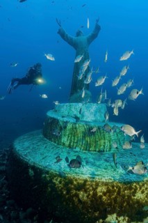A diver looks at the illuminated statue of Christ, the ‘Cristo degli Abissi' at San Fruttuoso, the