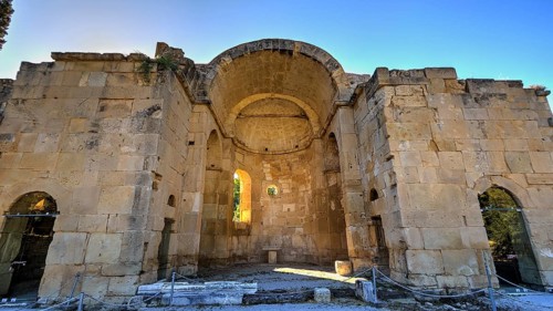 Titus Basilica, ancient ruin with vaulted yellow stone ceiling surrounded by impressive walls,