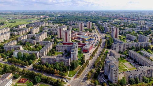 Aerial view of a sprawling urban residential area with multiple soviet buildings and greenery,