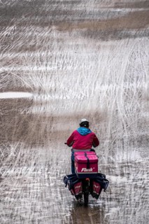 Dirt road, with many traces of two-wheelers, footprints, delivery service Flink Radkurier, wet,