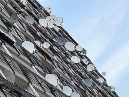 Satellite antennas on the façade of the Pallasseum, a heritage-protected residential complex in the