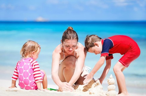 Young mother with two children playing in the sand on the beach, child, children, playing,