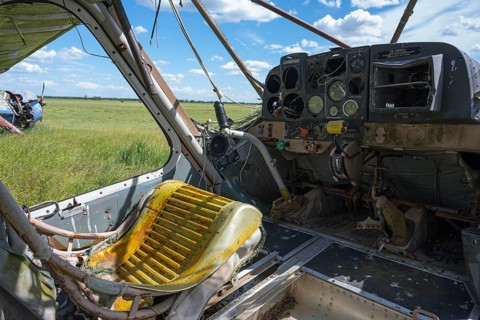 A dilapidated cockpit of an aircraft with a rusty seat and old flight instruments, cockpit and