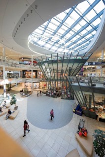 Interior of a shopping center with distinctive glass structure and hustle and bustle, Milaneo,