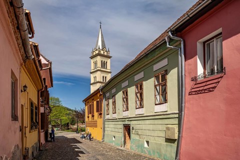 The colorful houses of the citadel and the Roman Catholic Church of St. Joseph in Sighisoara or