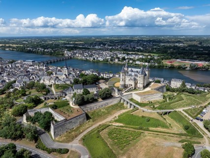 Aerial view of the historic Château de Saumur with its distinctive round corner towers and bright