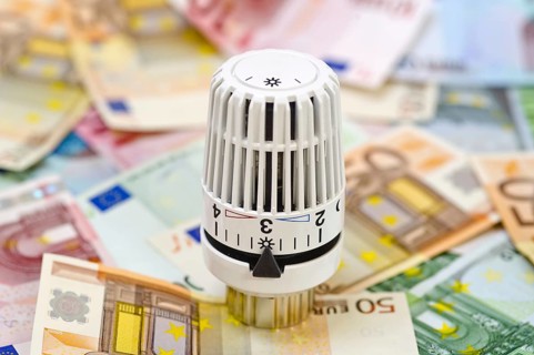 Symbolic photo of energy costs, heating valve with euro banknotes, heating thermostat, studio photo