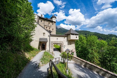 Footpath and entrance to Hohenwerfen Castle, behind the rocky peaks of the Tennengebirge, Werfen,