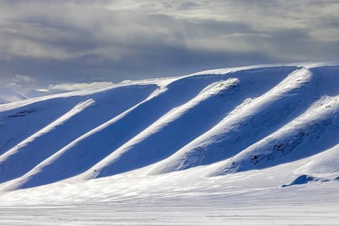 Snow covered mountain slope in Arctic landscape at Mohnbukta, bay at the western shore of