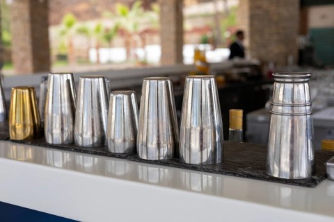 Sleek bar tools are organized on a counter, showcasing a professional setup for cocktail