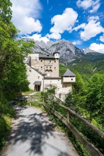 Footpath and entrance to Hohenwerfen Castle, behind the rocky peaks of the Tennengebirge, Werfen,