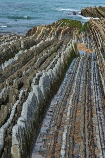 Distinctive rock cliffs as a geological formation of rock layers, Flysch on Itzurun Beach in