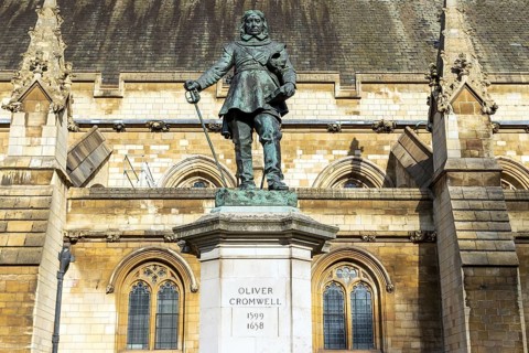 The bronze figure of Oliver Cromwell by Hamo Thornycroft stands before the medieval facade of