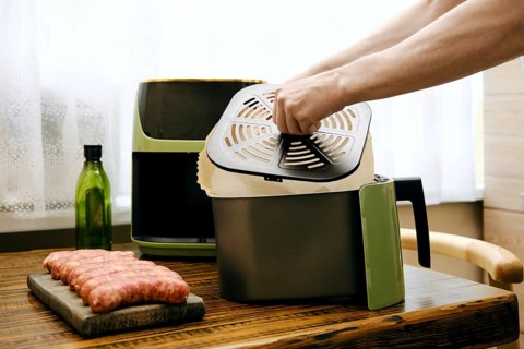Placing parchment paper under crisper tray of air fryer basket to ensure proper circulation of hot