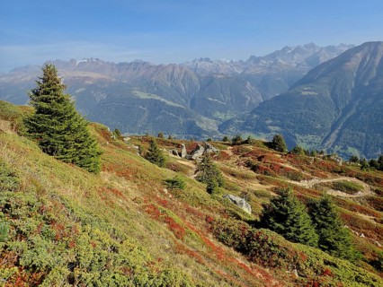 Significant mountain scenery with colorful, autumnal slopes under blue skies, views of distant