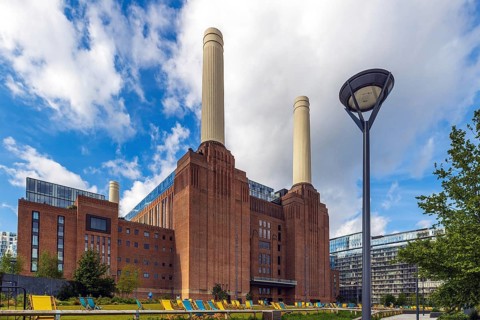 An ornate lamp post stands before the Art Deco chimneys of the restored Battersea Power Station,