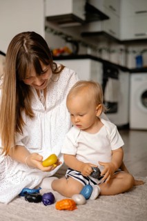 Mother and child holding toys and interacting in a cozy room