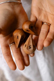 Close-up of hands holding numbered wooden dice, showcasing their detailed texture