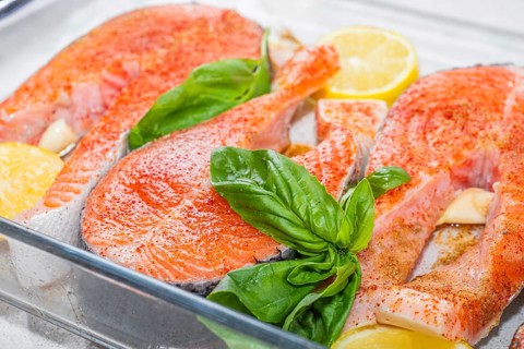 Salmon. Fresh raw salmon red fish fillet steak with cooking ingredients on glass background, top