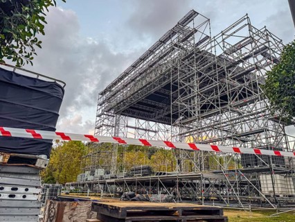 Construction site with scaffolding and safety barriers. Metal framework for a stage under assembly.