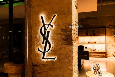 Vienna, Austria - 15 December, 2025: Illuminated YSL logo on a textured wall in Vienna, Austria.