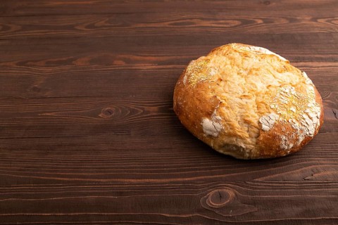Homemade bread on brown wooden background, copy space, side view