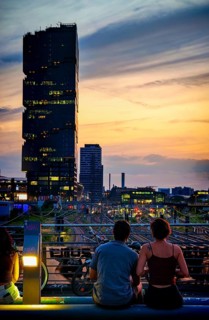 Romantic scene, view from Modersohn Bridge towards EDGE East Side high-rise building, evening