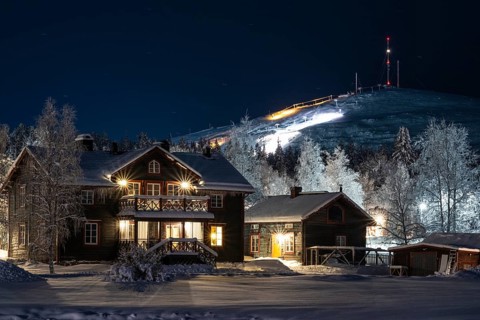 Illuminated house in snow with Mount Dundret, Gällivare, Norrbotten, Lapland, Sweden