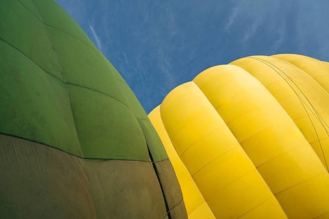 Yellow and green hot air balloons against clear blue sky, partial view, Close-up of vibrant green