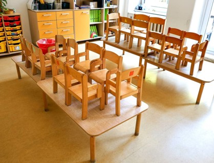 High-standing wooden chairs in the empty group room of a daycare center, Berlin, 11.08.2026,