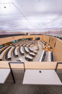 Large meeting room with curved rows of wood under a bright ceiling, Baden-Württemberg State