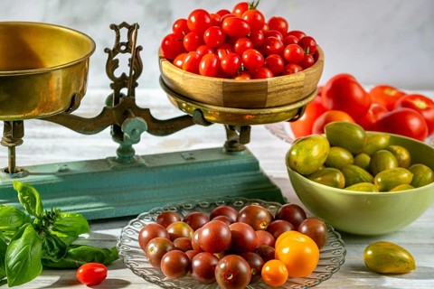 Old scale with fresh tomatoes and basil, rustic arrangement, natural colors