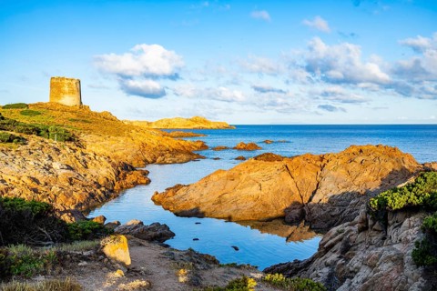 An old tower at the coast at Marinedda at sunset, Sardinia, Italy