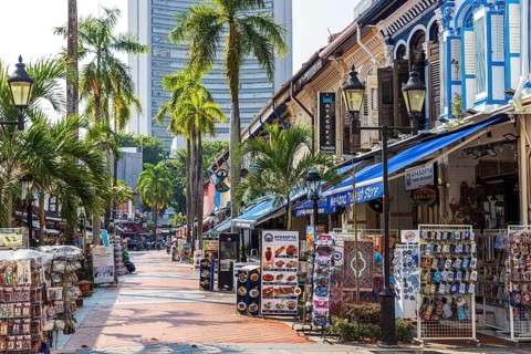 Colourful market stalls and shops filled with diverse souvenirs and accessories in a sunny outdoor